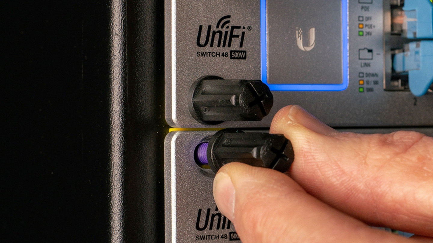 Hand screwing cap onto Rackstud mounted device